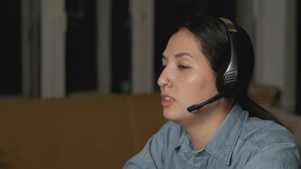 Serious  girl student wear headphone study online with internet teacher learn language talk 
