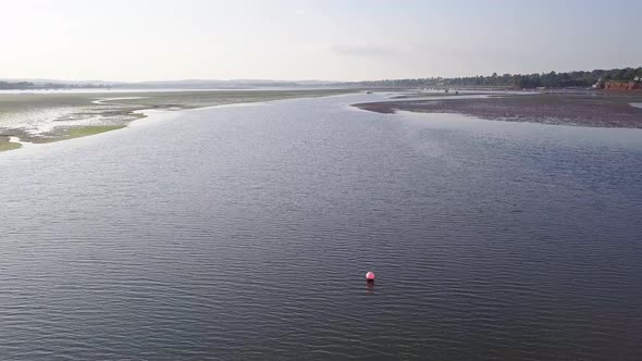 Sky view of mass of ocean water at the coastal town of Lympstone England. A buoy in the water is obs