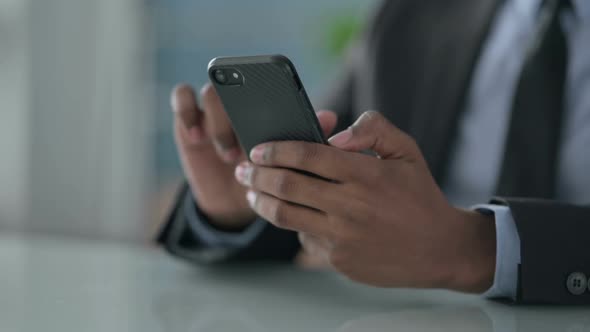 Close up of Hands of African Businessman using Smartphone
