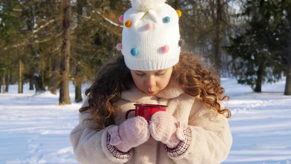 Little Girl with Cup of Hot Tea in Winter Park