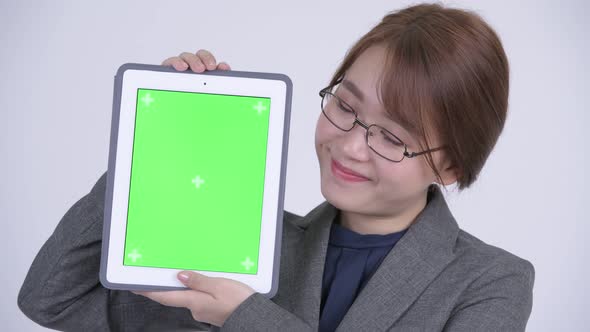 Face of Young Happy Asian Businesswoman Showing Digital Tablet