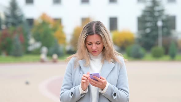 girl Using Mobile Phon on city street.