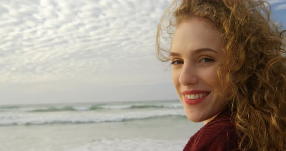 Close-up of young beautiful caucasian woman smiling and looking at camera on the beach 4k