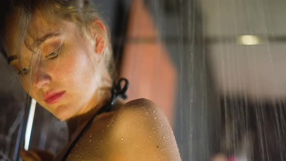 Blonde Woman Puts Back Under Falling Water Jets at Showering