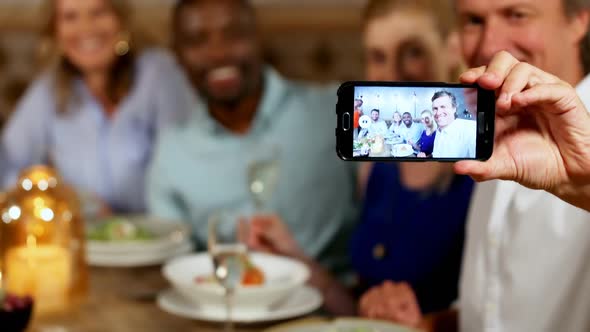 Man taking selfie with friends on a dinner table 4K 4k