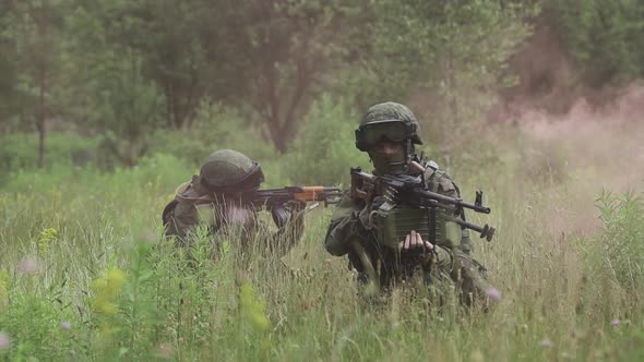 Soldiers in Camouflage with Assault Rifles Out of the Ambush in the Field Military Action in the
