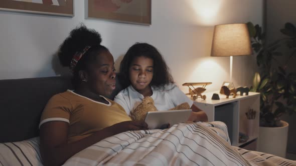 Aunt Reading Book to Girl at Night