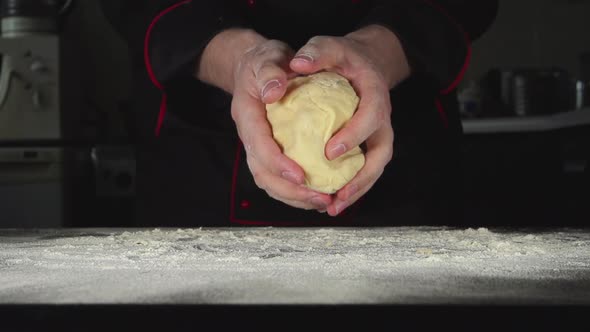 Baker Kneads A Dough On A Cutting Board In A Kitchen