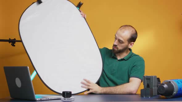 Photographer Discussing About White Reflector