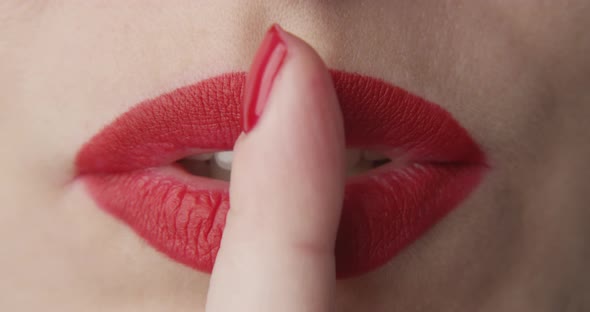 Macro Of Lips With Red Lipstick And A Finger Showing Hush And Silence
