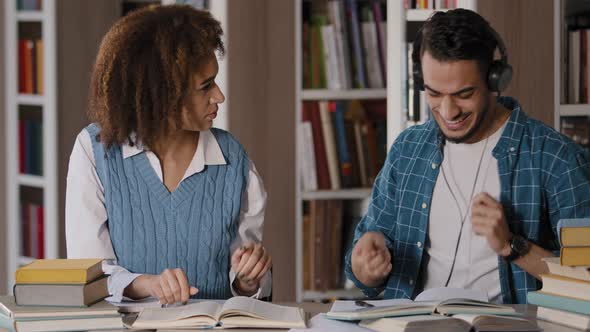 Students in Library Preparing for Exam Doing Homework Funny Young Guy Listening Music in Headphones