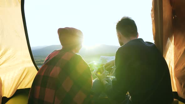 Young Man and Woman Exploring Map in the Mountain