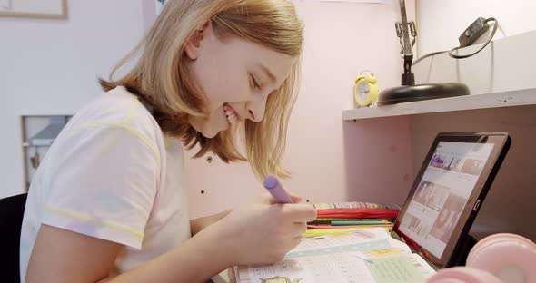 The Teenager is at Home Drawing at the Table the Children's Room in Pink Colors