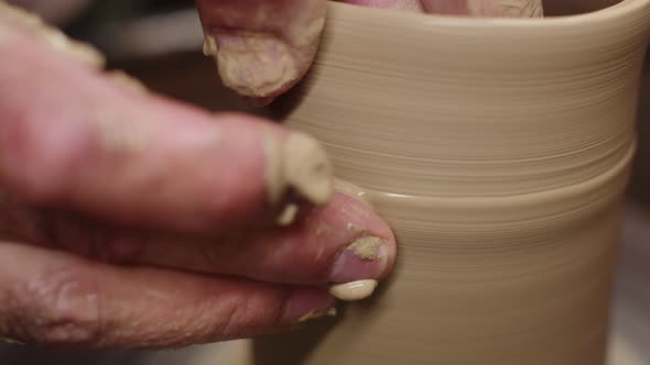 Artisans Hands Give the Spinning Clay on the Potters Wheel Shape By Sliding His Fingers Over It