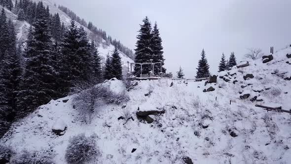 A Broken Gazebo Stands on Snowy Hill in Mountains