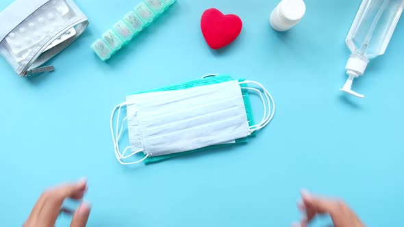 Top View of Man Hand Holding Surgical Face Mask on Blue Background