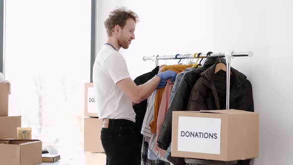 Young Volunteer Checking Clothes Donation Box and Making Notes Humanitarian Aid