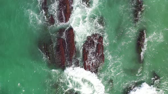 Drone footage of ocean waves on rocks