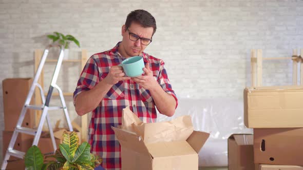 Man Unpacks a Box of Dishes During the Move and Finds Damage