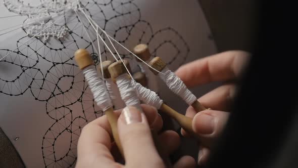 Detail Closeup of Female Hands Weaving Lace with Bobbins