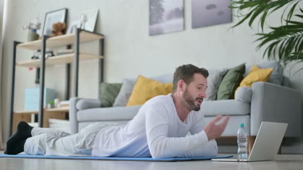 Man Doing Video Call on Laptop While on Yoga Mat