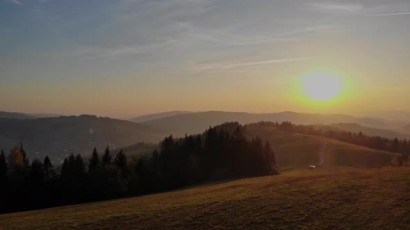 Flight over autumn mountains in the light of the setting sun.