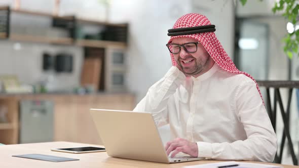 Stressed Young Arab Businessman with Laptop Having Neck Pain in Office 