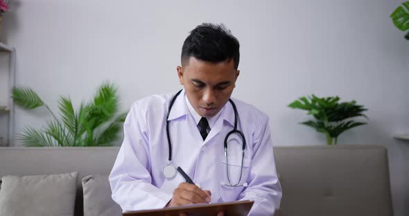 Doctor listening to patient and writing on clipboard