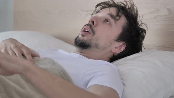 Casual Young Man Waking Up in Bed By Scary Dream Nightmare
