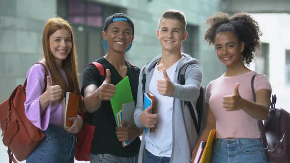 Smiling Multiethnic Students With Books Showing Thumbs Up, College Choice