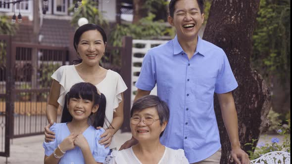 Asian Multi Generational Family Looking at Camera and Smiling at Home