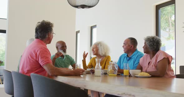 Happy senior diverse people having breakfast at retirement home