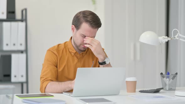 Young Man Having Headache in Office 