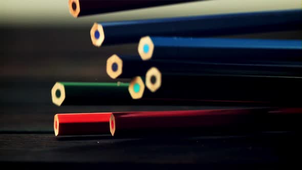 Colored Pencils Fall on a Wooden Table