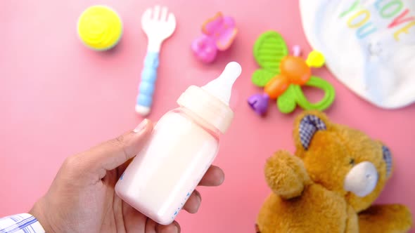 Holding Milk Bottle with Toys for Newborn Baby Set with Teddy Bear on Pink