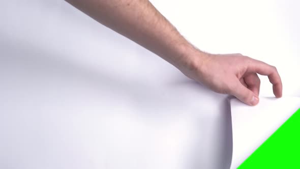 Male Hand Flips a White Sheet of Paper on a Green Screen.