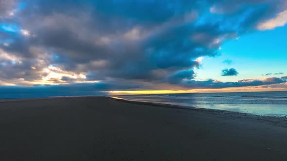 Time lapse of dark clouds moving over a beach, during sunset, on Langeoog island