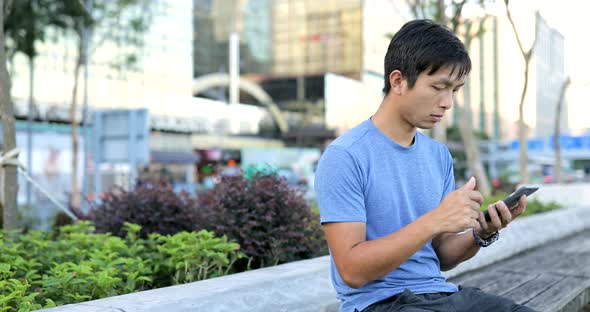 Young Man using cellphone in city 