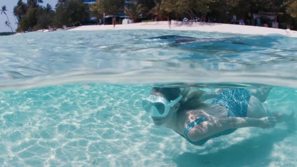 Splitted View of the Woman in Mask Gliding Underwater Over the Sandy Bottom