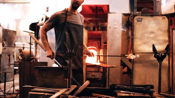 Glassblower shaping a molten glass