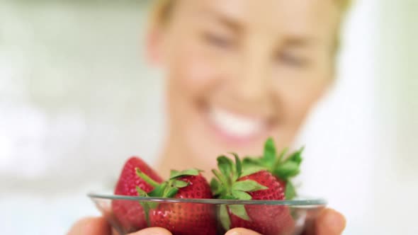 Portrait of smiling woman holding a bowl of strawberry