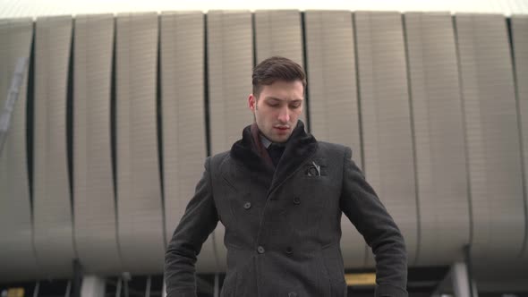 Businessman arranging his coat and smiling