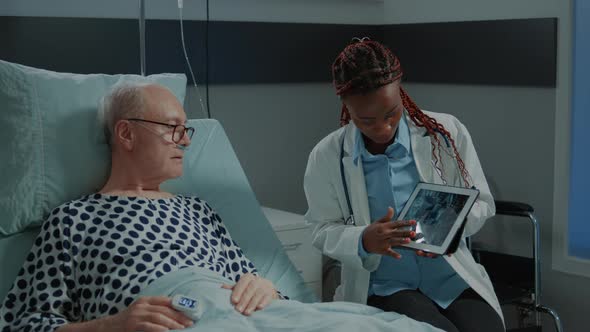 African American Doctor Showing Xray on Tablet to Patient