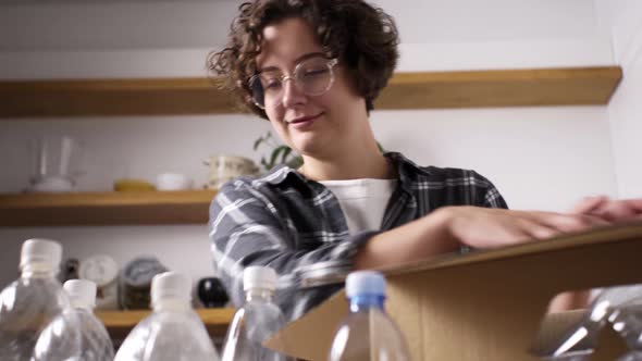 Young Caucasian Girl Stacks Plastic Bottles For Recycling Recycling Reuse In A Cardboard Paper Box