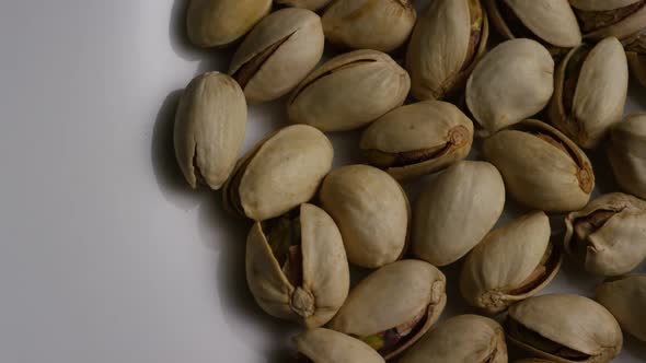 Cinematic, rotating shot of pistachios on a white surface - PISTACHIOS 006