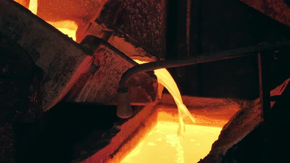 Foundry Mechanism is Pouring Molten Copper Into a Mold