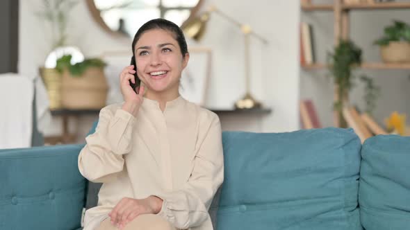 Indian Woman Talking on Smartphone on Sofa