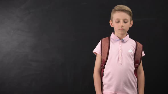 Unhappy Tired Schoolboy Standing Near Chalkboard, Suffering Overload at School