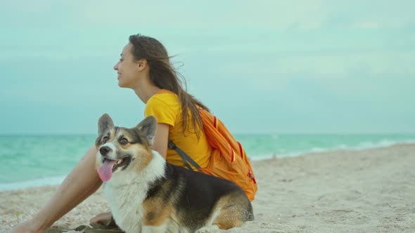 Attractive Young Woman Smiling and Spending Time Together with Her Pet Cute Corgi Dog Outdoors at