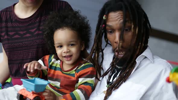 Positive African Father Playing with Toddler Son